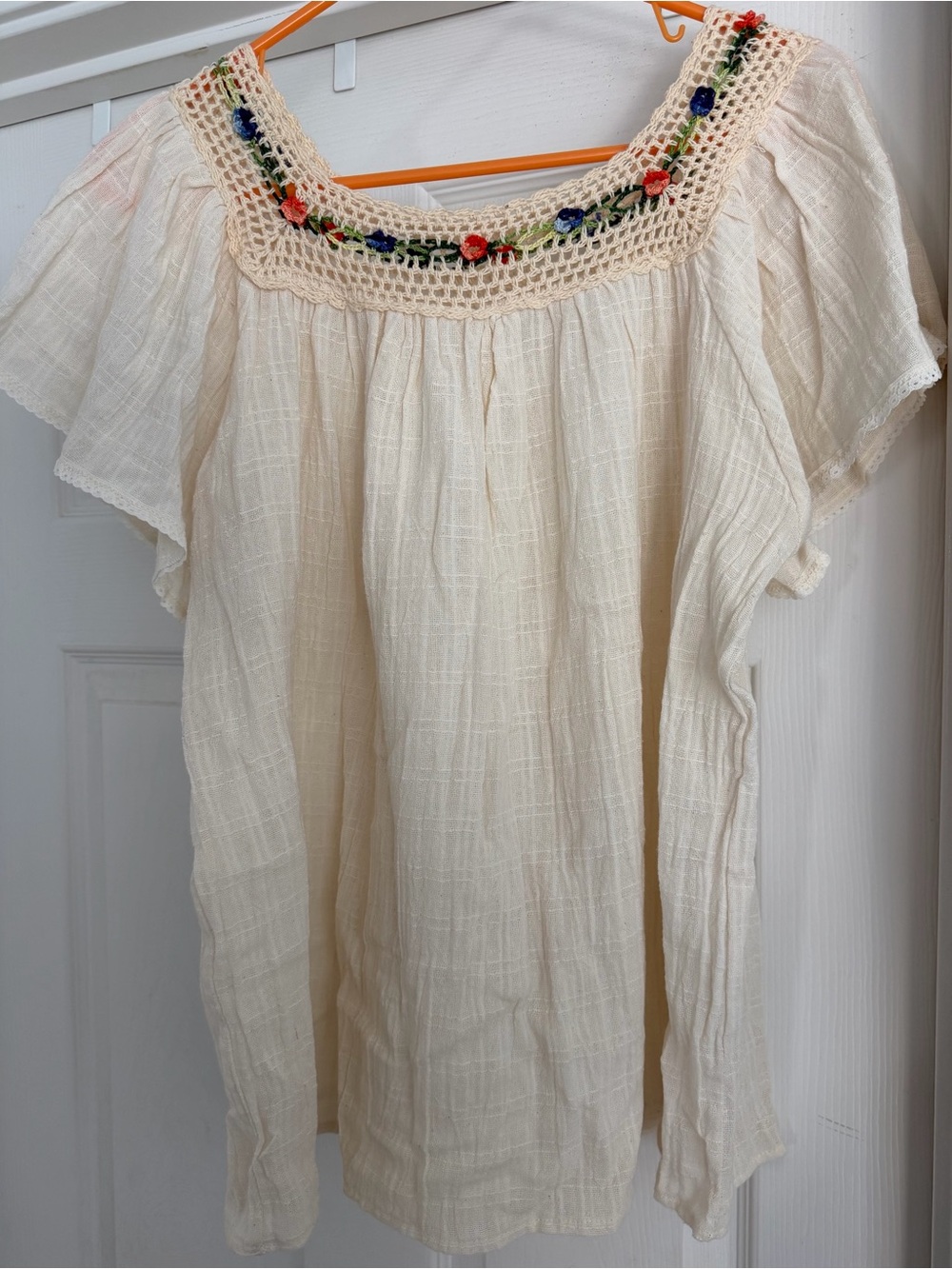 Cream blouse, short sleeve, with crochet floral detail across top and back